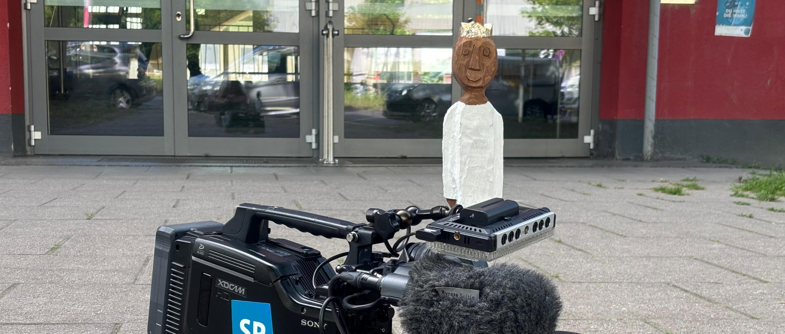 Königsfigur auf einer Kamera des SR vor der Marienschule