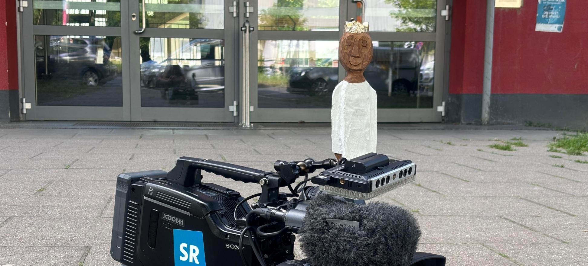 Königsfigur auf einer Kamera des SR vor der Marienschule