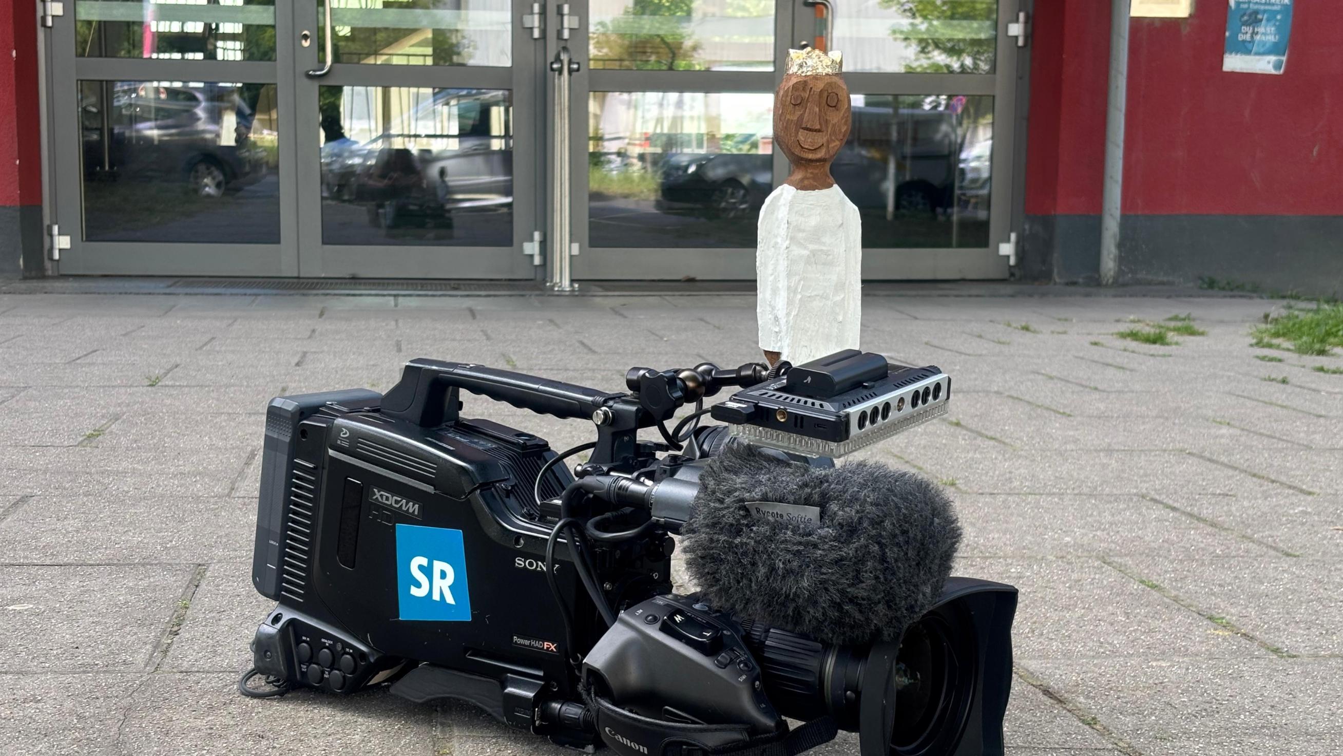 Königsfigur auf einer Kamera des SR vor der Marienschule