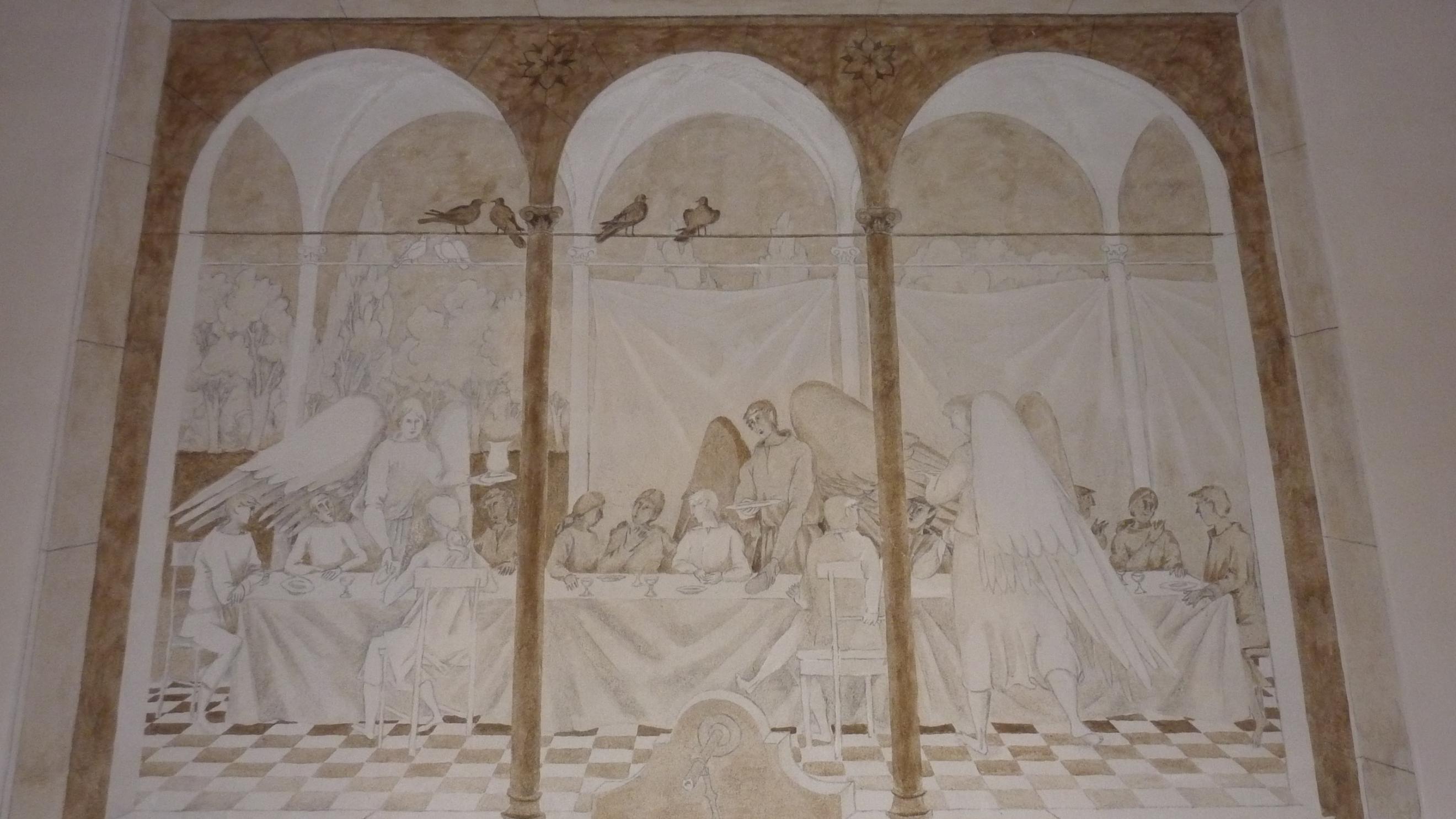 Das Foto zeigt ein Wandbild in der Kirche St. Monika in Überherrn, in einer offenen Galerie werden zwölf Personen von drei Engeln bewirtet.