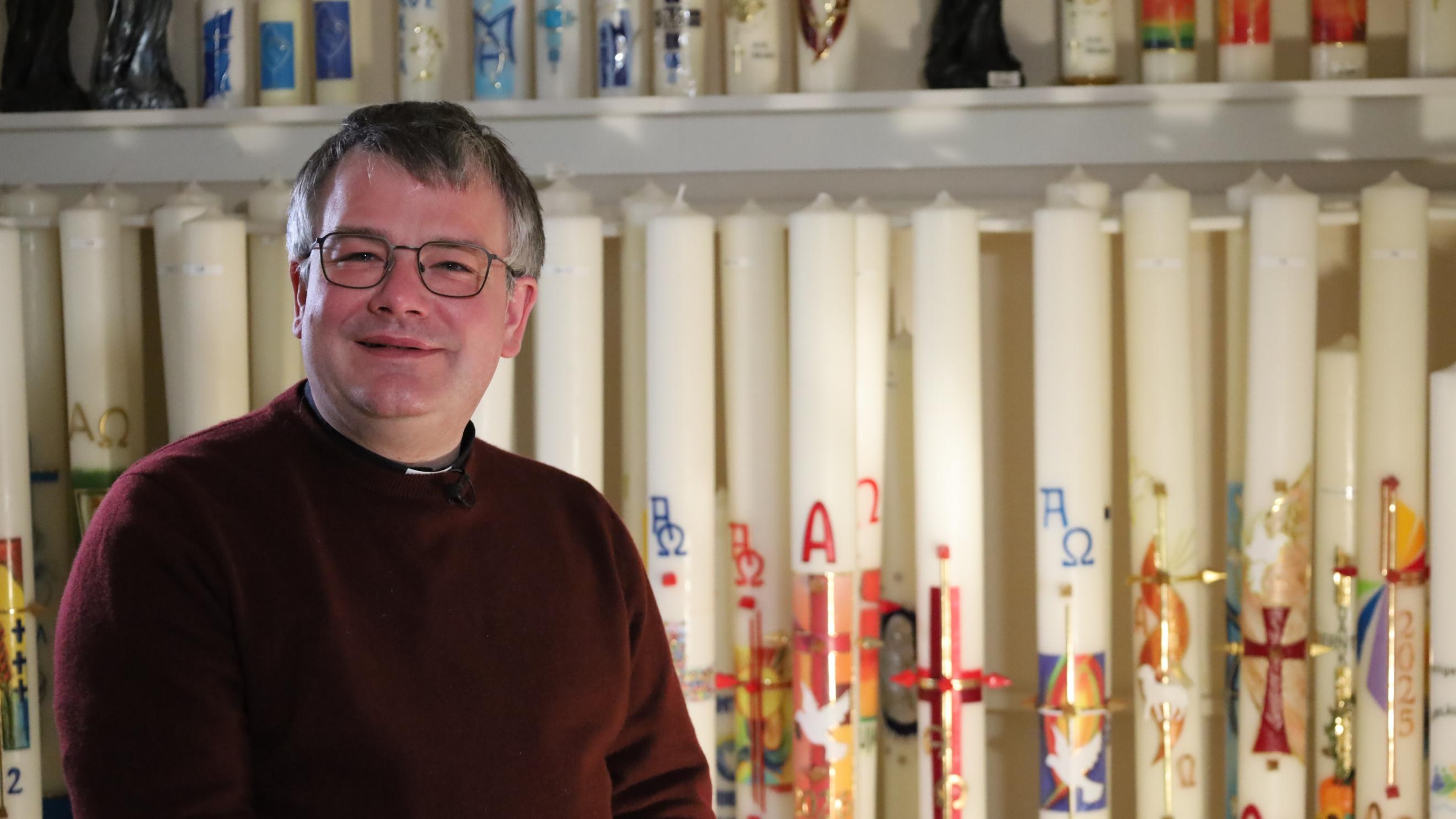 Christian Heinz vor einem Regal mit Kerzen in der Kerzenfabrik Pazen