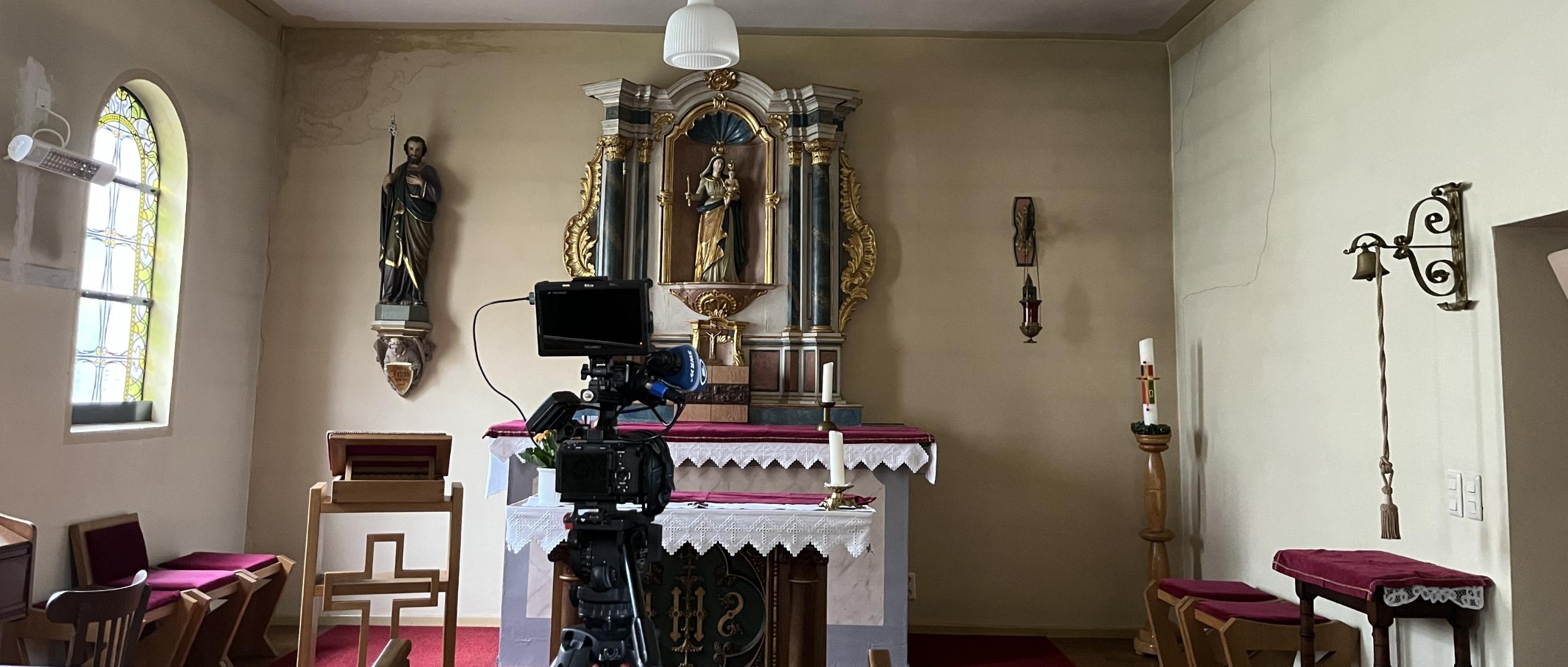 Blick auf den Altar mit einer Filmkamera des SR im Vordergrund